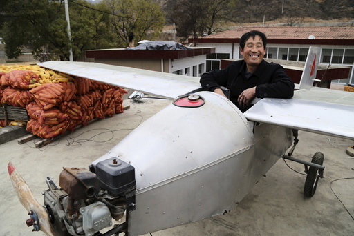 Chen, 50-year-old farmer, sits in his homemade plane to pose for a photograph on the roof of his house in Qifu village of Pingliang