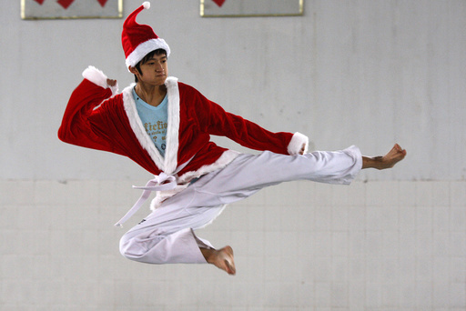 A student dressed in a Santa Claus costume to celebrate Christmas, practises taekwondo at a sports school in Suining