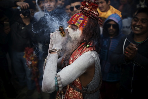 A Hindu holy man, or sadhu, smeared with ashes smokes marijuana in a chillum during the Shivaratri festival in Kathmandu