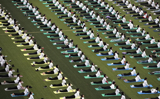 Hundreds of participants practice yoga at a charity event to mark the upcoming World AIDS Day, at an university in Guilin