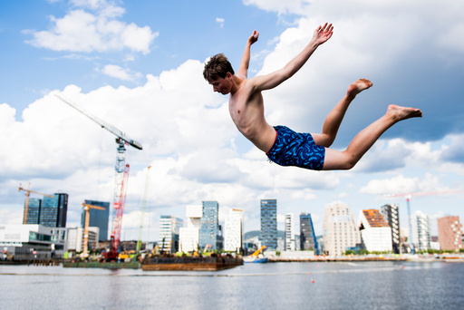 Kim Morten Buer (18) hopper i havet på en av årets varmeste sommerdager på Sørenga i Oslo torsdag ettermiddag.