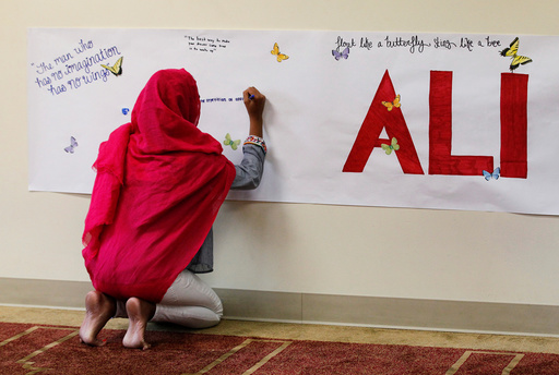 A member of the Louisville Islamic Center writes messages on a memorial banner as she pays her respect to Muhammad Ali, the former world heavyweight boxing champion after he died at the age of 74 on Friday at the Islamic Center in Louisville