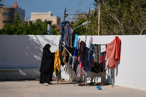En kvinne som er drevet på flukt, henger opp klesvask ved Makassed-universitetet i Beirut tirsdag.