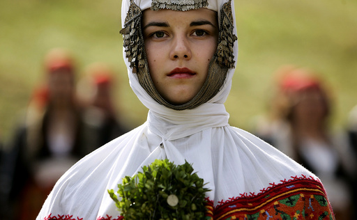 Bulgarian woman dressed in a traditional wedding dress participates in the Rozhen folklore festival in the Rhodope mountains