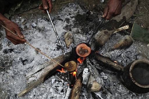 Naga men cook raw opium as they prepare it for smoking at a hunter's base in an opium field during a hunting trip between Donhe and Lahe township in the Naga Self-Administered Zone