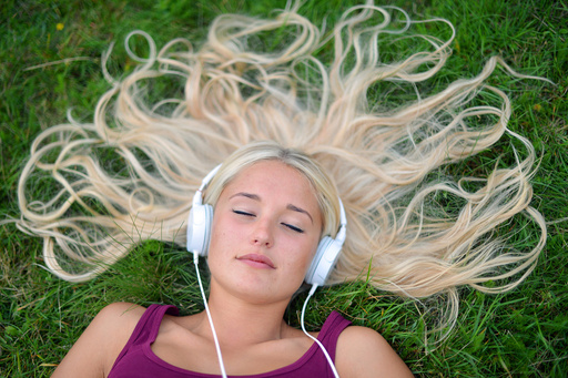 Young blonde woman listening to music