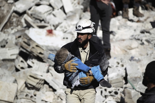 A civil defence member carries a dead child in a site hit by what activists said were airstrikes carried out by the Russian air force in the rebel-controlled area of Maaret al-Numan town in Idlib province, Syria