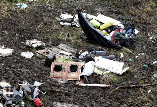 A rescue worker sits near the wreckage of a plane that crashed into the Colombian jungle with Brazilian soccer team Chapecoense onboard near Medellin