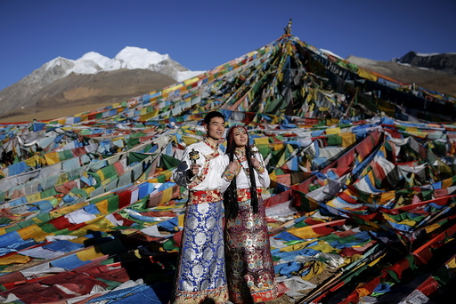 Jing Li (L) and her husband Ke Xu wear Tibetan traditional costumes as they pose for their wedding photos at the Nianqing Tanggula mountain pass in the Tibet Autonomous Region,