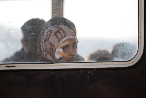 A girl sits in bus evacuating fighters and civilians from two besieged Shi'ite towns of al-Foua and Kefraya in mainly rebel-held northwestern province of Idlib, as they wait to cross to Turkey from the Syrian-Turkish border crossing of Bab al-Hawa