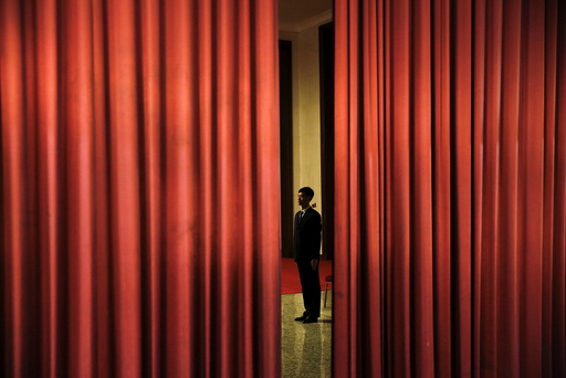 A security agent guards the area behind curtains inside the Great Hall of the People where sessions of the National People's Congress (NPC) are taking place, in Beijing