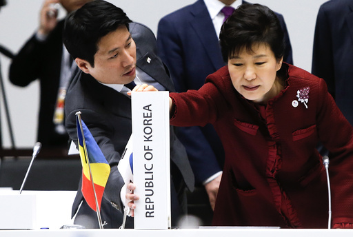 South Korea's President Park Geun-hye adjusts the country placeholder during the Asia-Europe Meeting (ASEM) in Milan