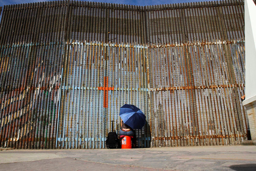 A woman talks to her relatives across a fence separating Mexico and the United States, in Tijuana