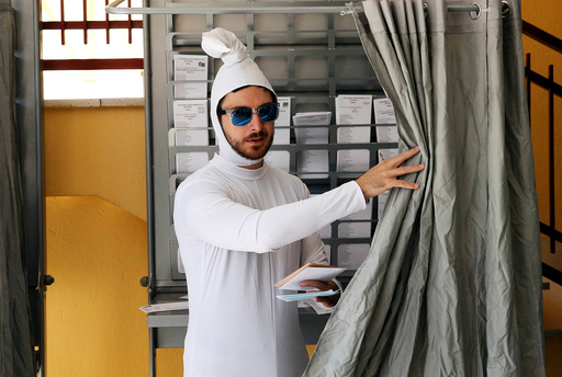 A man dressed as a sperm prepares his ballot at a polling station before voting in Spain's general election in Madrid