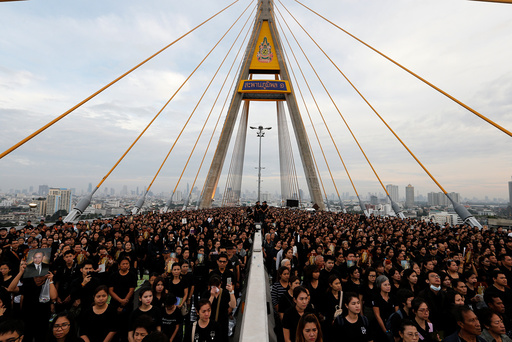 People gather during an event to mark late Thai King Bhumibol Adulyadej's birthday at Bhumibol Bridge over Chao Phraya river in Bangkok