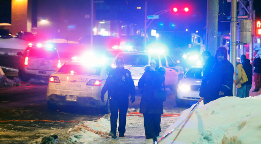Police officers are seen near a mosque after a shooting in Quebec City