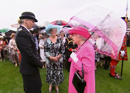 Still image of Britain's Queen Elizabeth speaking to Commander Lucy D'Orsi during a garden party at Buckingham Palace in London