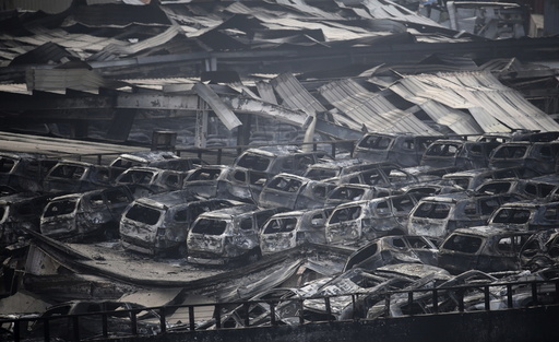 Damaged vehicles are seen at the site of explosions in Tianjin