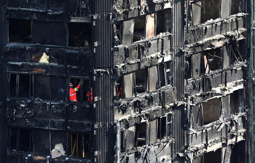 Members of the emergency services work inside burnt out remains of the Grenfell apartment tower in North Kensington, London