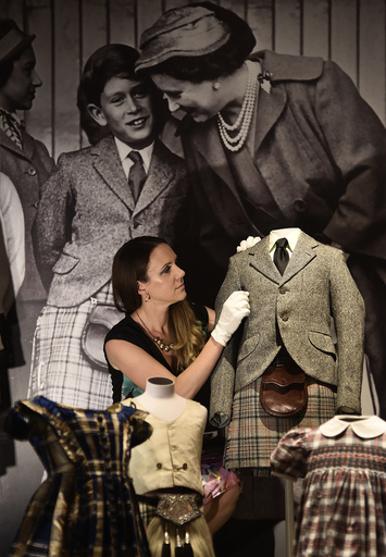 Curator of Royal Collection Trust Anna Reynolds poses with a kilt and jacket belonging to Prince Charles from 1958 at Buckingham Palace in central London