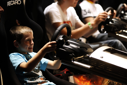 Visitors play ''Gran Turismo'' at an exhibition stand at the Gamescom 2010 fair in Cologne