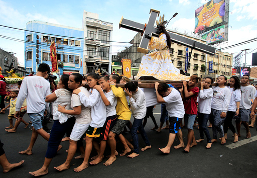 Barefoot devotees parade with replica of a Black Nazarene two days before the annual procession of the Black Nazarene in metro Manila