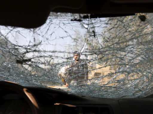 An Afghan man is seen through the cracked side window of a vehicle at the site of a suicide car bomb attack in Surkhrod district of Nangarhar province