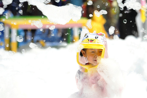 Child plays inside a pool filed with foam bubbles in Huaian, Jiangsu