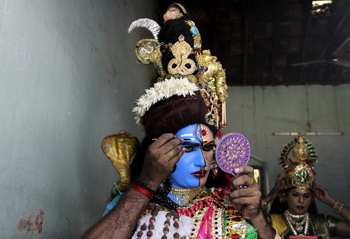 A man dressed as Hindu God Ardhnarishwar gets ready to take part in a performance during festivities marking the start of the annual harvest festival of 