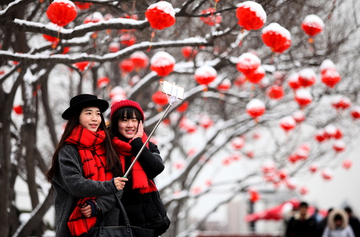 Tourists take selfies after a snowfall in Xi'an