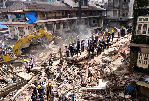 Firefighters and rescue workers search for survivors at the site of a collapsed building in Mumbai