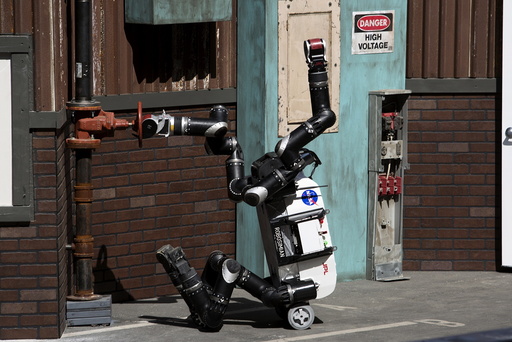 The Jet Propulsion Lab team's RoboSimian robot turns a valve on a simulated disaster-response course during day one of the DARPA Robotics Challenge finals in Pomona