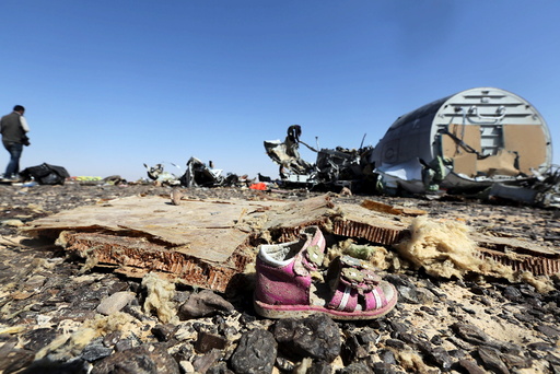 A child's shoe is seen in front of debris from a Russian airliner which crashed at the Hassana area in Arish city