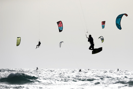 People kitesurf in the Mediterranean sea in Tel Aviv