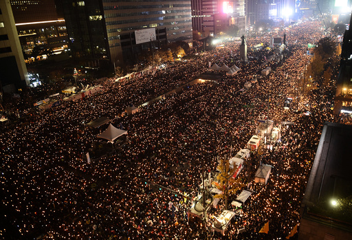 Protesters hold candles during an anti-government rally in central Seoul
