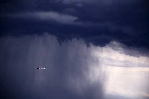 A Qantas Boeing 737-800 plane flies through heavy rain as a storm moves towards the city of Sydney, Australia