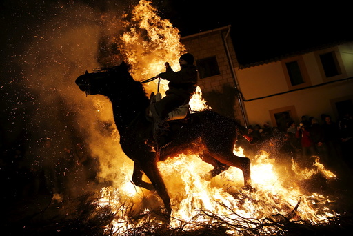 A man rides a horse through the flames during the 