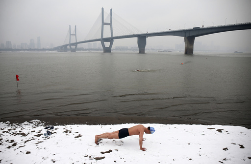 A winter swimmer does push-ups on the snow-covered banks of the Yangtze River, in Wuhan