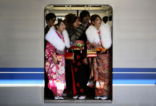 File photo of Japanese women in kimonos riding a train after a ceremony celebrating Coming of Age Day at an amusement park in Tokyo