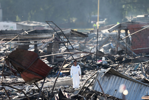 An investigator stands amidst the wreckage of houses destroyed in an explosion at the San Pablito fireworks market in Tultepec