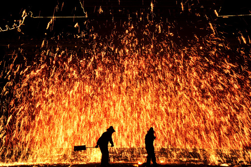Local artists perform folk art of making shower of sparks from molten iron during an event celebrating China's Lunar New Year in Anyang