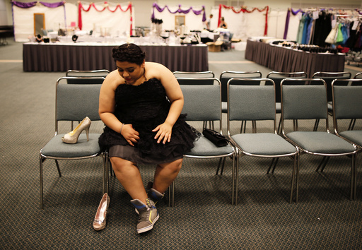 Elemmar Valle, 15, tries on a dress and shoes for her graduation dance at the Glamour Gowns event in Los Angeles