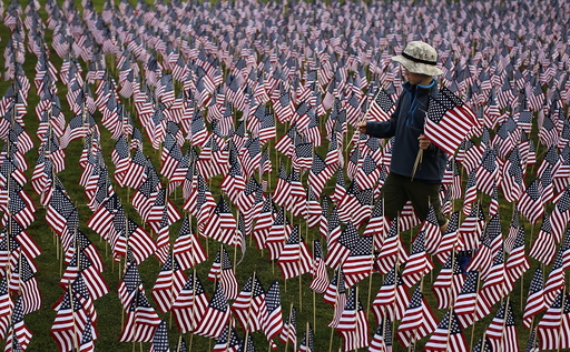 A boy walks among some of the 3,000 flags placed in memory of the lives lost in the September 11, 2001 attacks, at a park in Winnetka