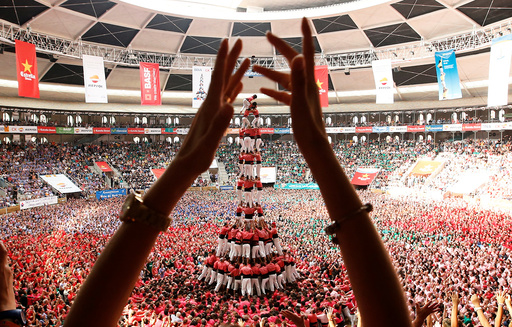 Colla Vella Xiquets de Valls form a human tower called castell, while a supporter applauds, during a biannual competition in Tarragona