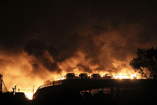 Vehicles are seen burning after blasts at Binhai new district in Tianjin municipality