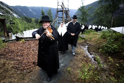 Knut Buen med sort skinnfrakk leder gravfølget i Marispelet. Teater, Sogelandet, Marispelet, Rjukan
