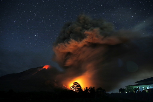 Hot lava flows from Mount Sinabung volcano during eruption as seen from Tiga Serangkai village in Karo Regency