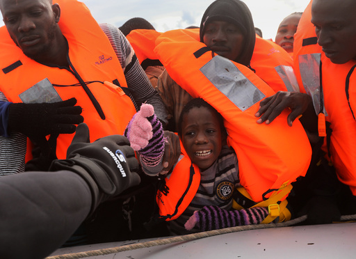 A child reacts among migrants as they try to reach a rescue craft from their overcrowded raft, while lifeguards from the Spanish NGO Proactiva Open Arms rescue all on aboard, in the central Mediterranean Sea