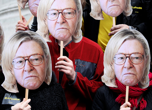 Activists wear masks depicting the face of Jean-Marie Le Pen, the founder of the French far-right National Front, with the hair of his daughter Marine Le Pen during a demonstration as part of traditional May Day labour day march in Paris