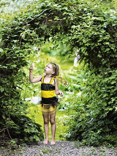 Girl in garden wearing bee costume